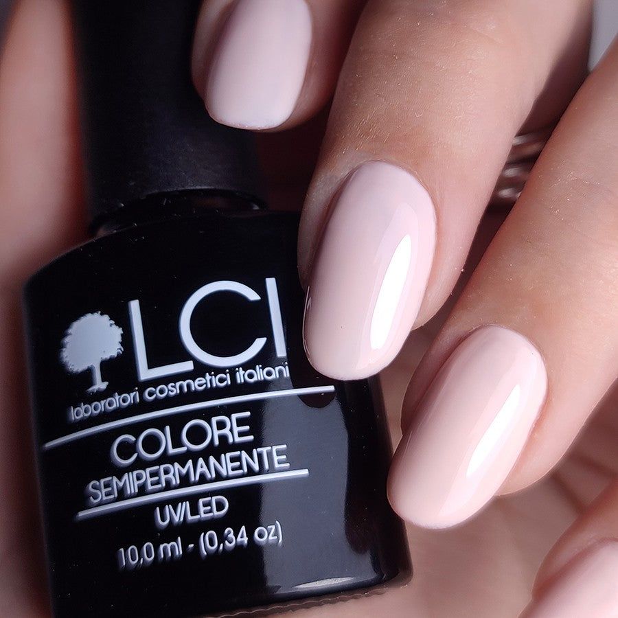 Flacone di smalto e unghie smaltate. Tonalità rosa. Flacone nero con testo bianco. Logo "LCI".