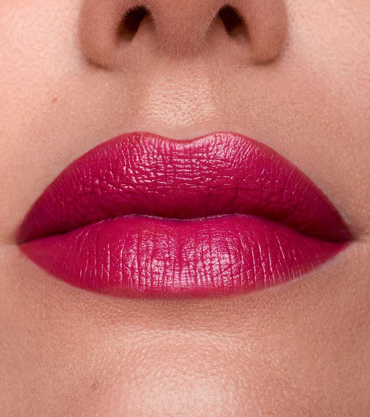 Primo piano di labbra con rossetto rosa acceso.
