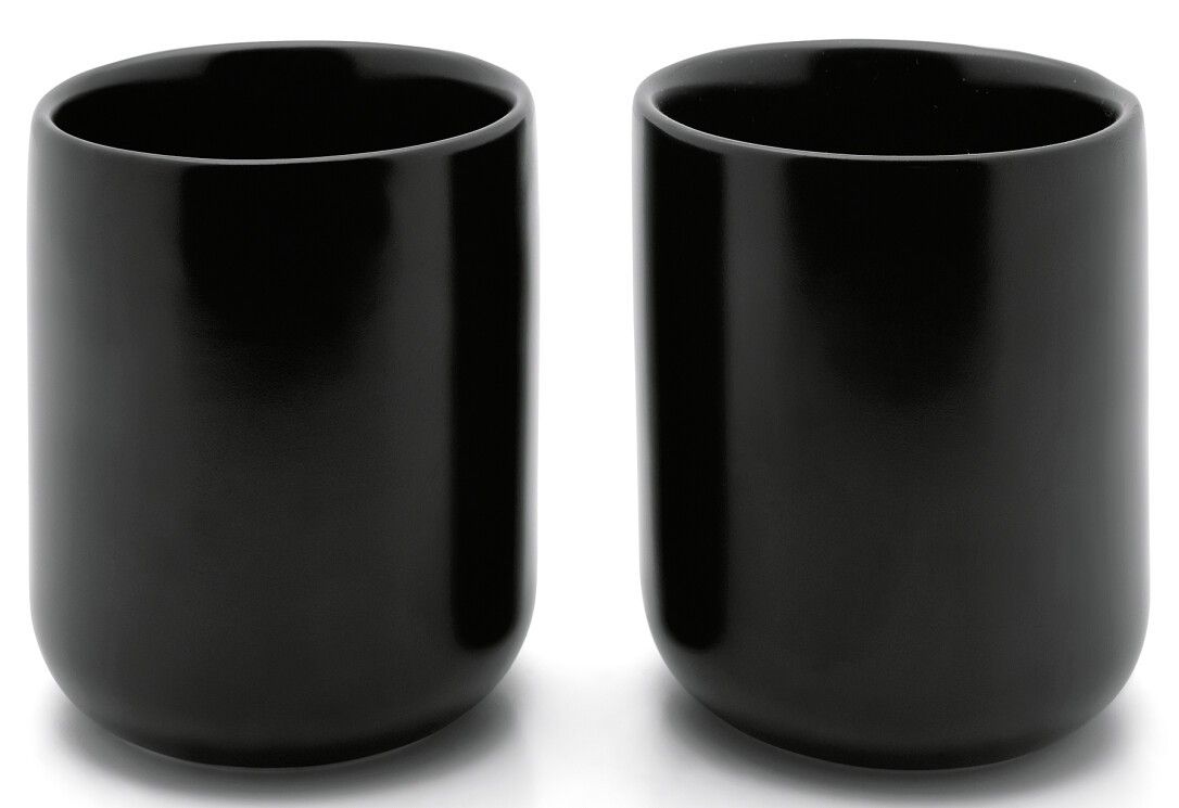 Due tazze da tè nere, cilindriche. Le tazze hanno fondi arrotondati. Lo sfondo è bianco.