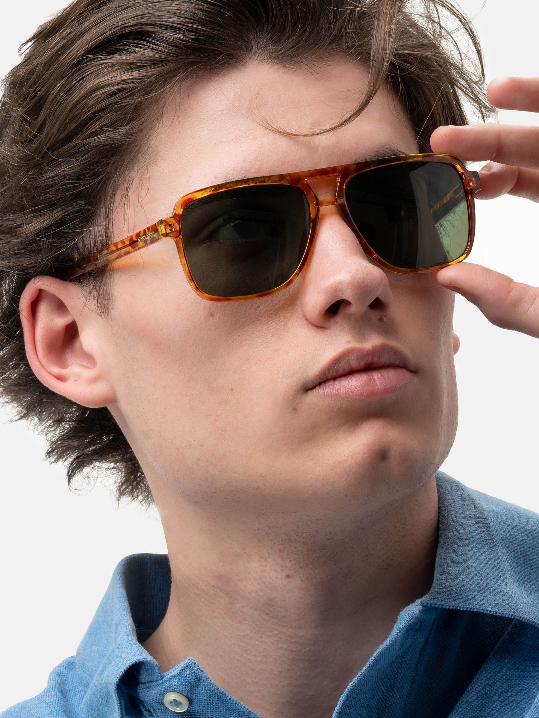 Uomo con occhiali da sole marrone-gialli e lenti verdi. "Smooder" è visibile.