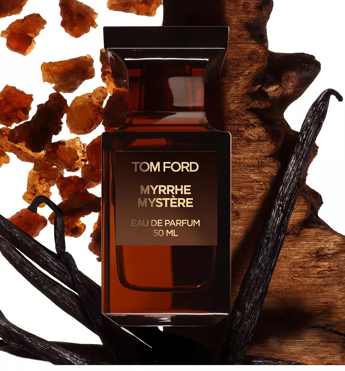 Flacone Tom Ford Myrrhe Mystère Eau de Parfum su legno e spezie. Vetro marrone, etichetta dorata.