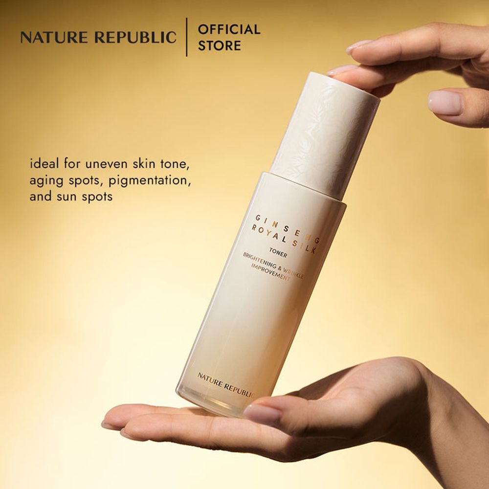 Flacone beige in mano, sfondo dorato. Testo: Ginseng Royal Silk Toner. Ideale per il tono della pelle irregolare.