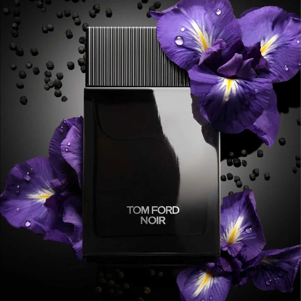 Flacone nero con tappo nero. Scritta TOM FORD NOIR in bianco. Circondato da fiori viola.