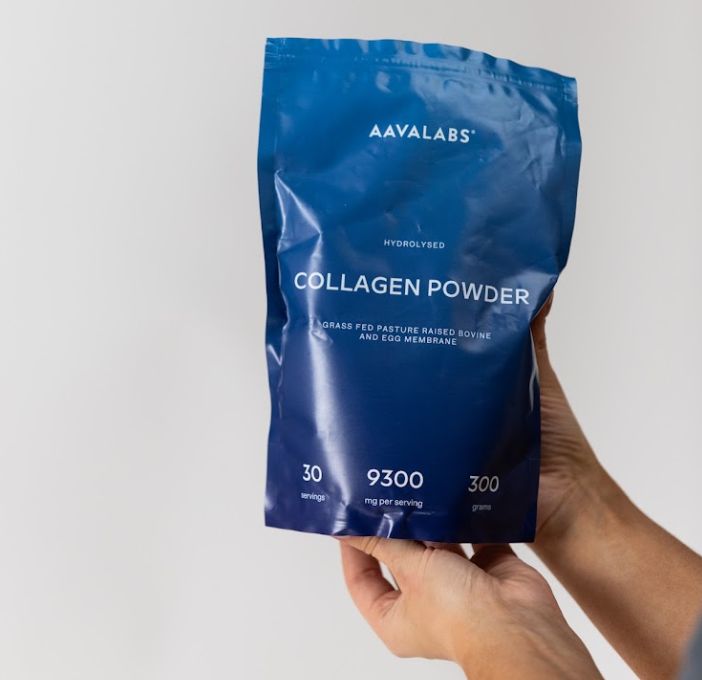 Mani che tengono una busta blu di polvere di collagene.