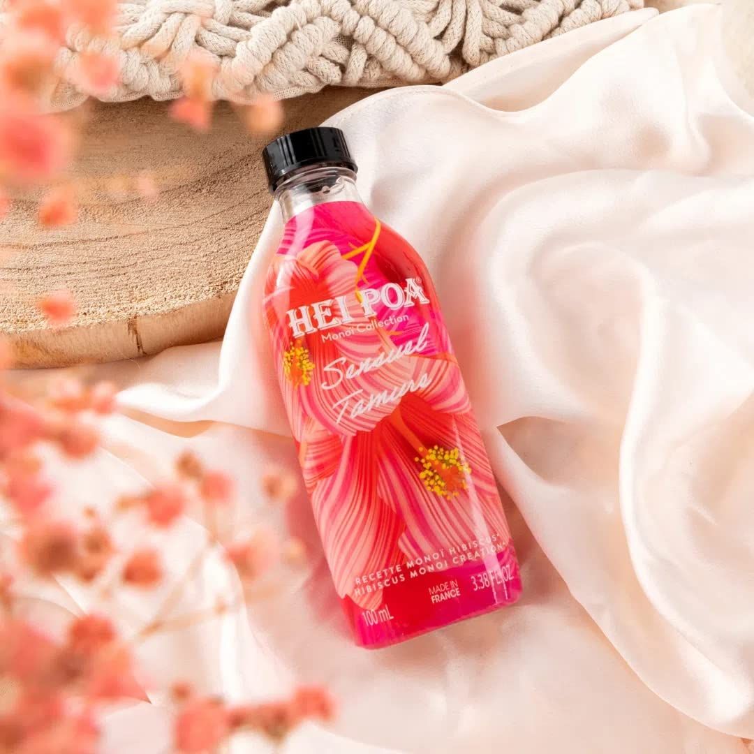 Flacone con liquido rosso e design floreale. Tappo nero. Scritta: HEI POA. Posizionato su seta.