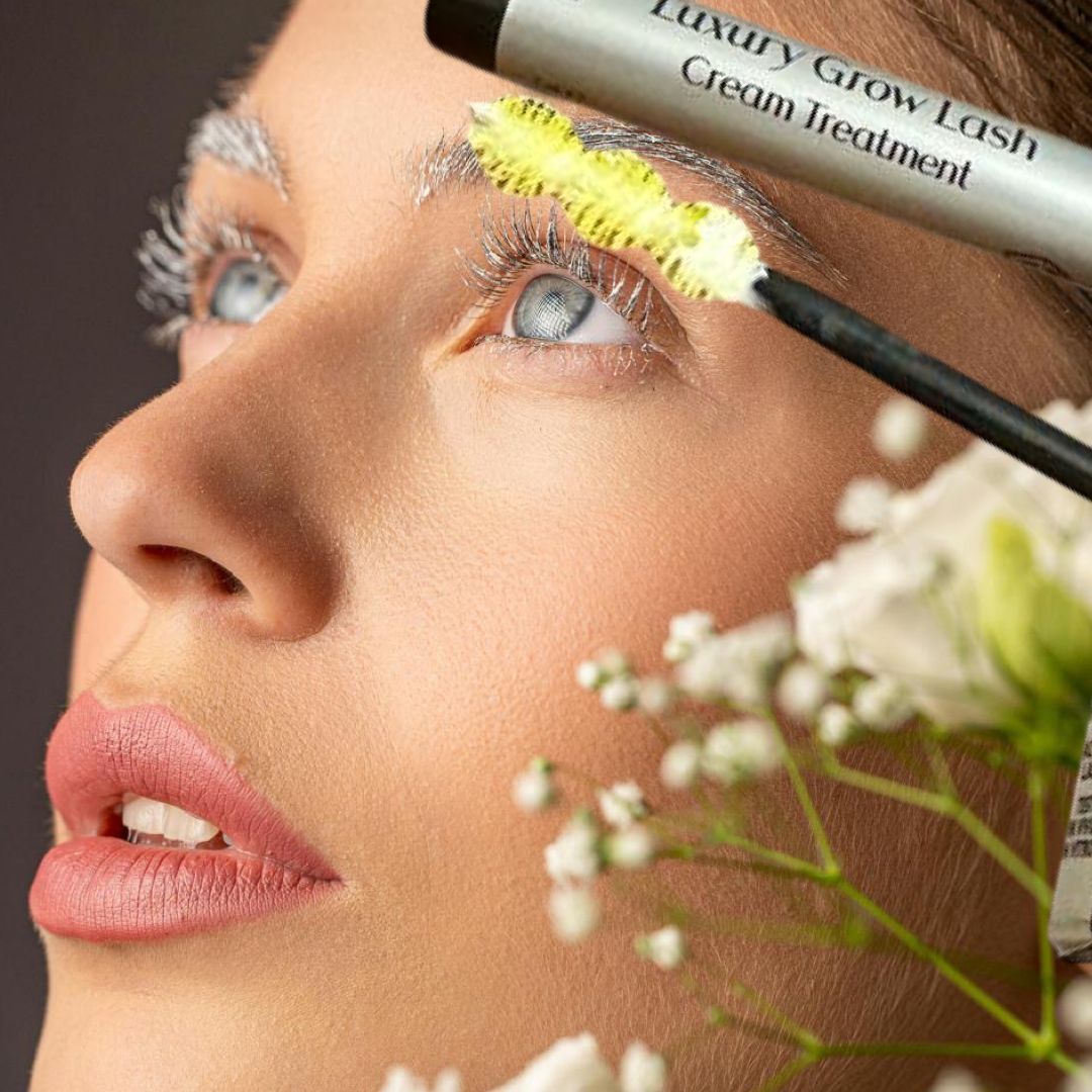 Donna con prodotto sulle sopracciglia. Testo: Luxury Grow Lash Cream Treatment. Spazzola gialla. Marchio: Amatè.