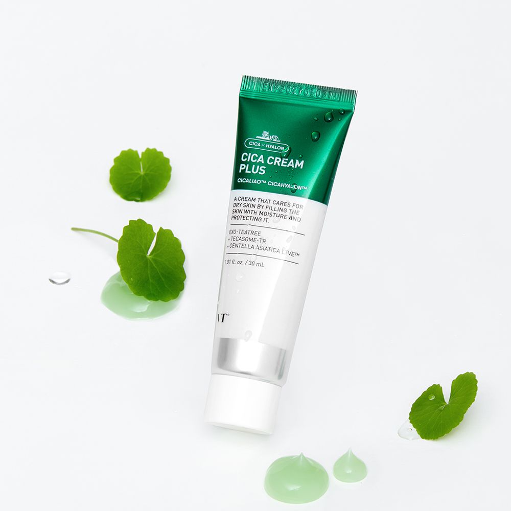 Tubo di Cica Cream Plus. Tubo verde e bianco con nome e ingredienti. Foglie e gocce di crema verde accanto.