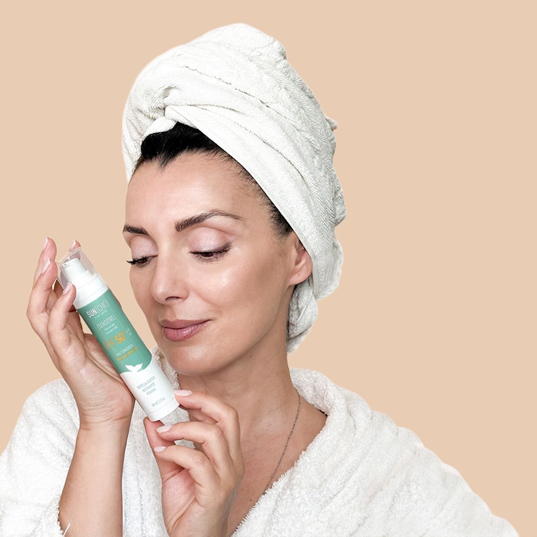 Donna tiene crema solare. Etichetta prodotto con testo. Donna con accappatoio e asciugamano.