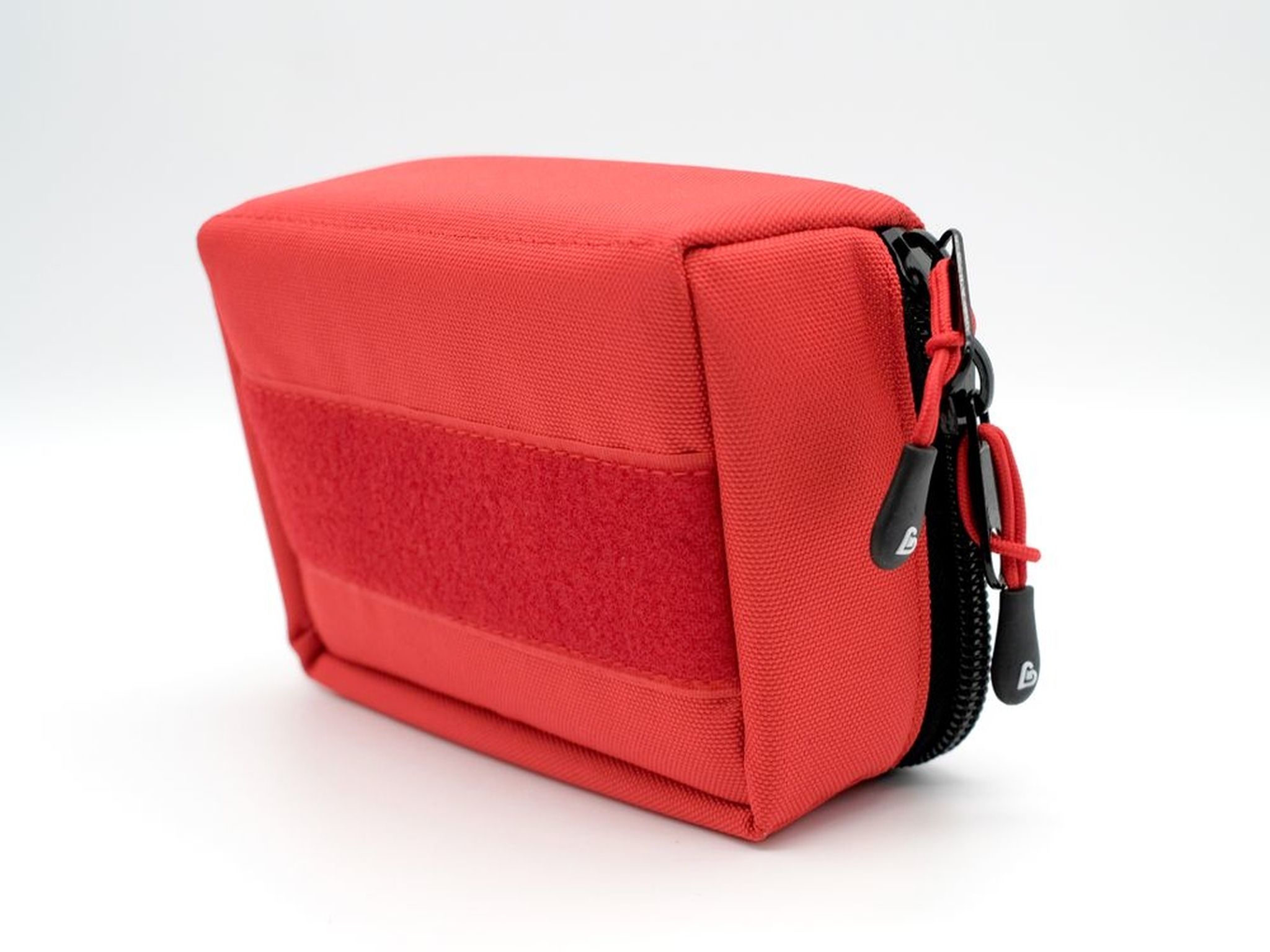Borsa d'emergenza rossa con area in velcro sul lato e tiretti neri della cerniera.