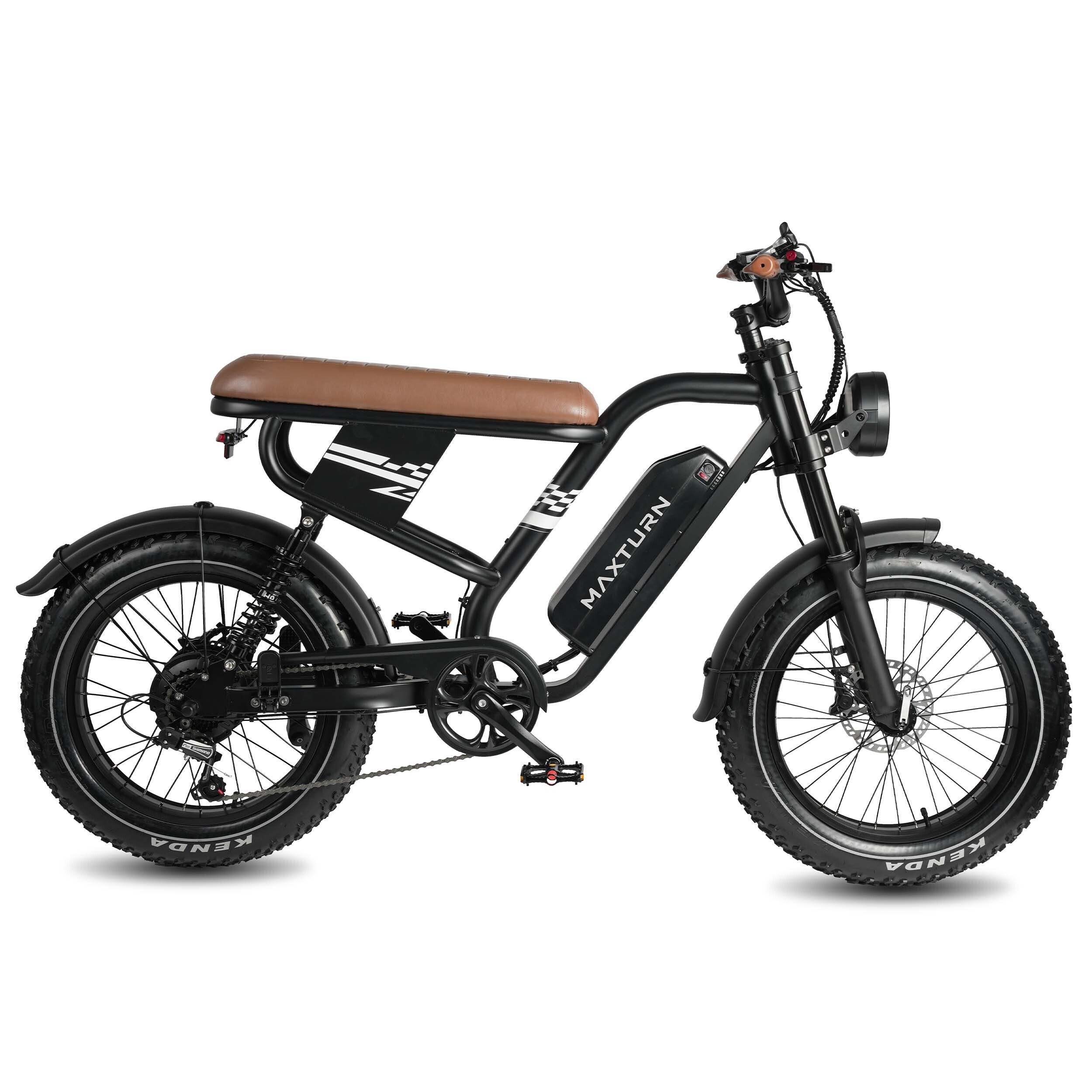 E-bike nera con sella marrone. Scritta "MAXTURN" sul telaio. Pneumatici larghi e faro.