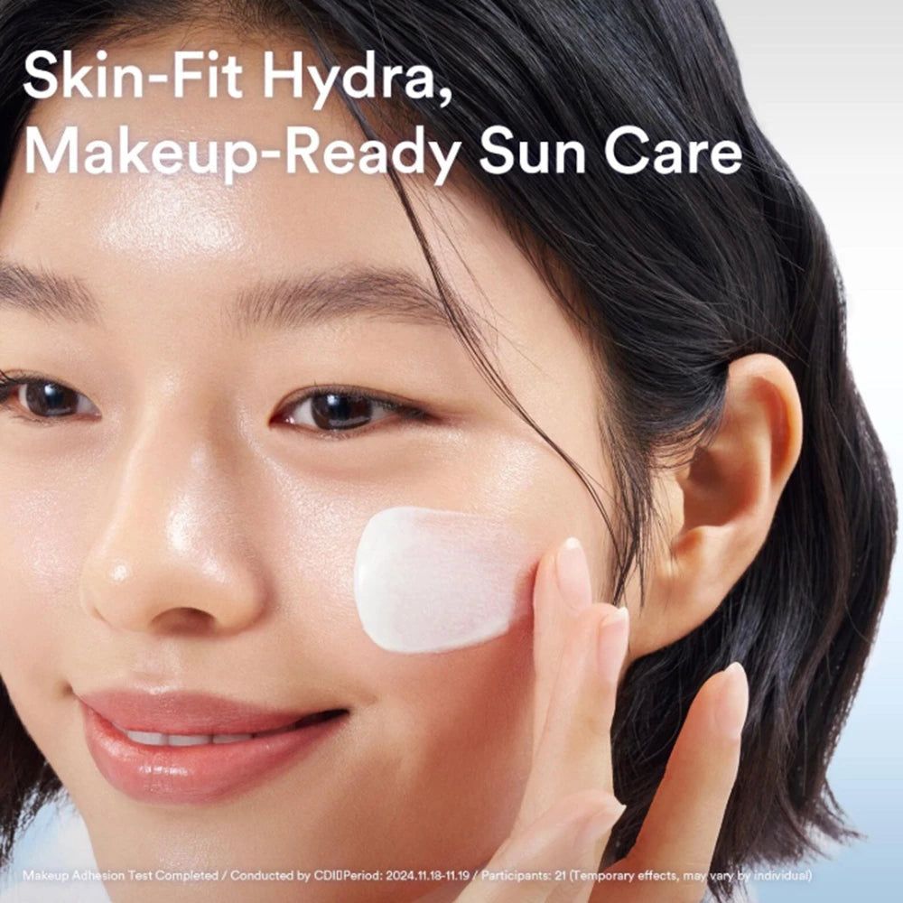 Una donna applica la crema solare Abib Sedum Hyaluron sulla guancia. La texture è leggera e acquosa.