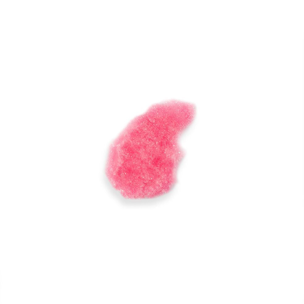 Grumo di sale da bagno rosa su sfondo bianco. Consistenza granulare.