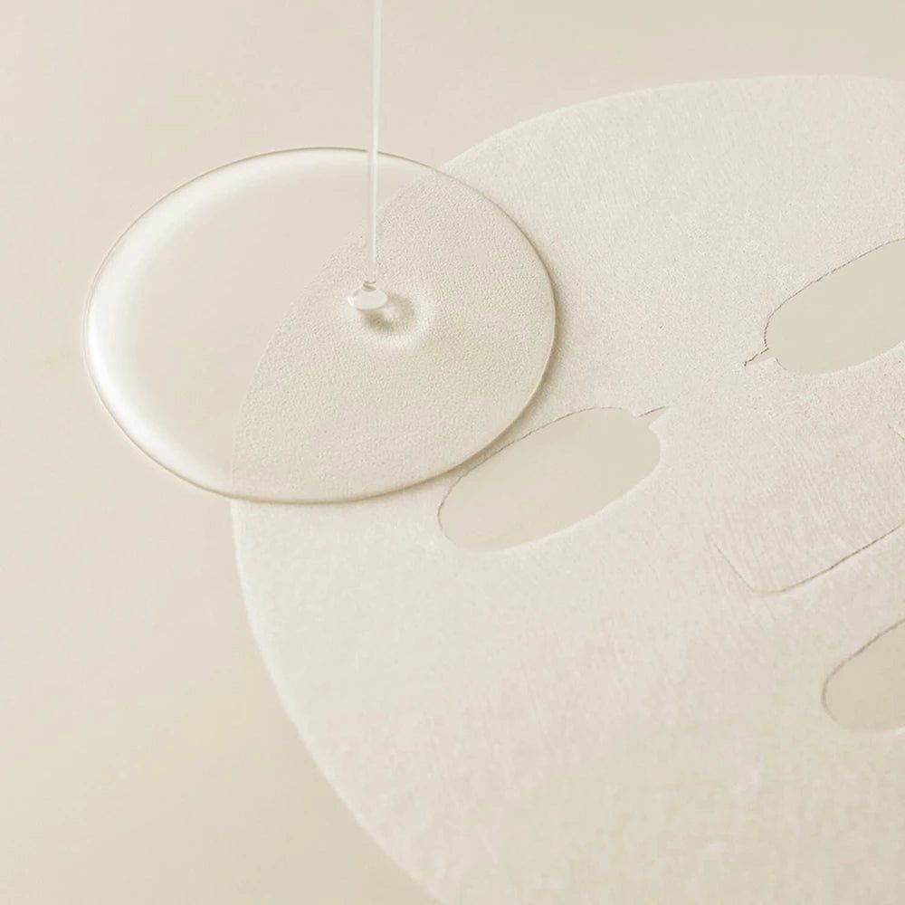 Una goccia di liquido cade su una maschera per il viso. La maschera ha aperture per occhi, naso e bocca.