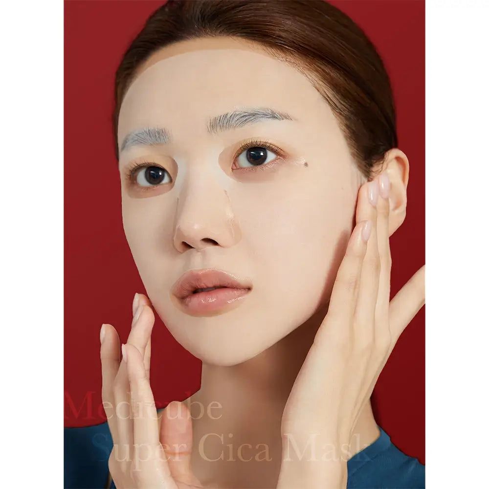 Maschera per il viso applicata. Mani che toccano le guance. Maschera copre sopracciglia e viso. Sfondo rosso.