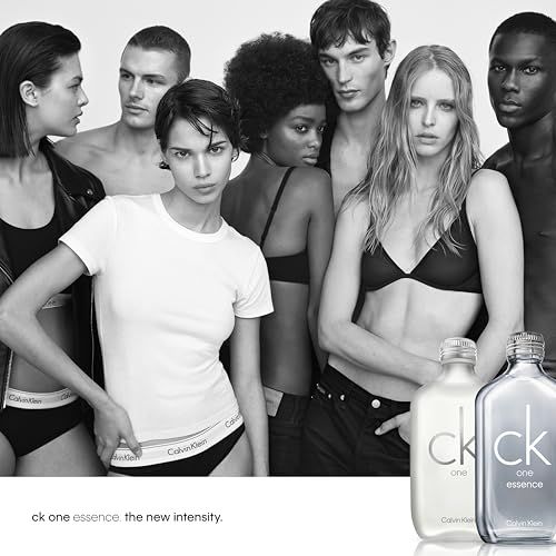Foto pubblicitaria con modelli. Due flaconi "ck one" in primo piano. Scritta "ck one essence the new intensity".