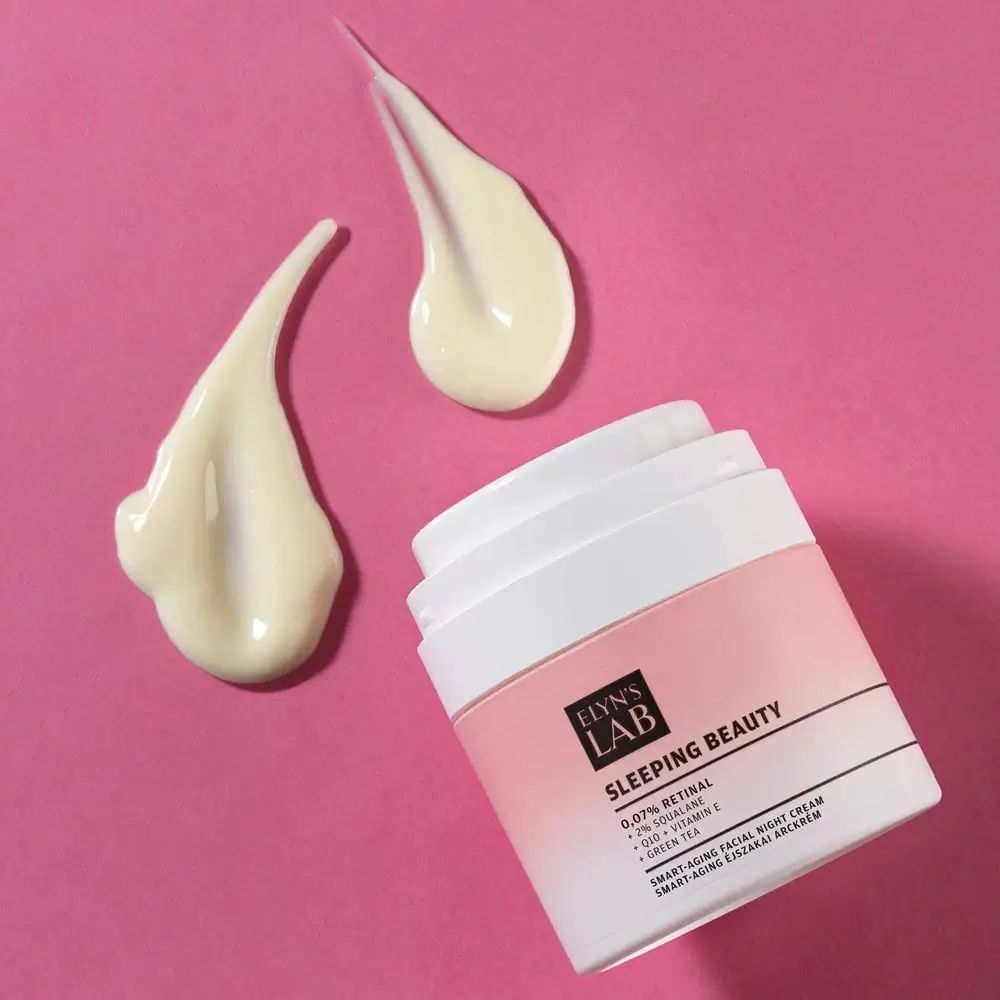 Vaso di crema con etichetta rosa e nome del prodotto. Accanto, tre gocce di crema. Scritta: ELYN'S LAB Sleeping Beauty 0,07% Retinal.