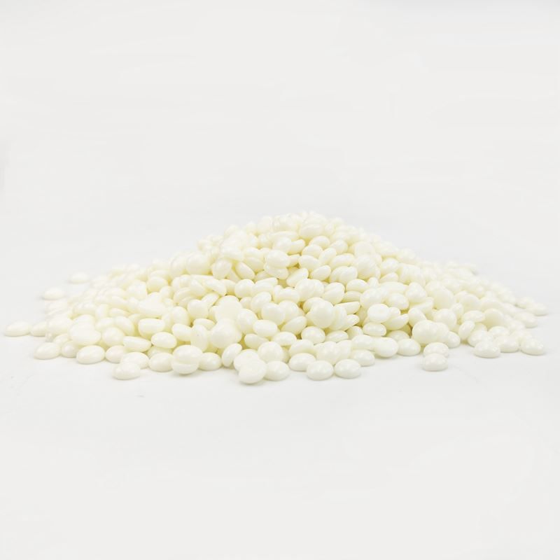 Una pila di pellet di cera bianca su sfondo bianco.