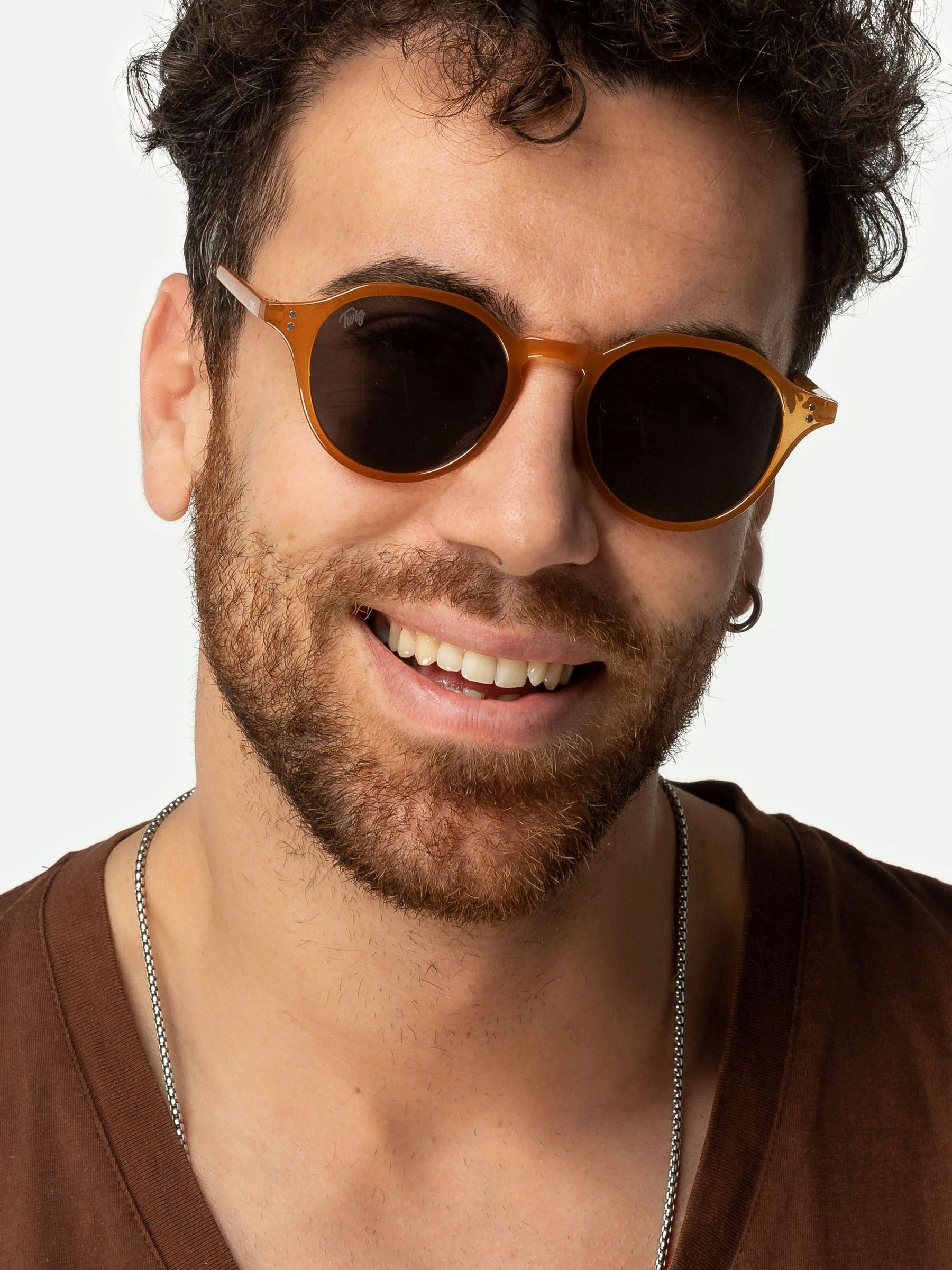 Uomo con occhiali da sole Twig Honey Orange. Montatura marrone, lenti scure.
