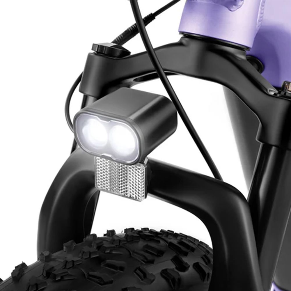 Primo piano dell'illuminazione della bicicletta. Alloggiamento nero con due luci a LED e riflettore. Montato sulla forcella.