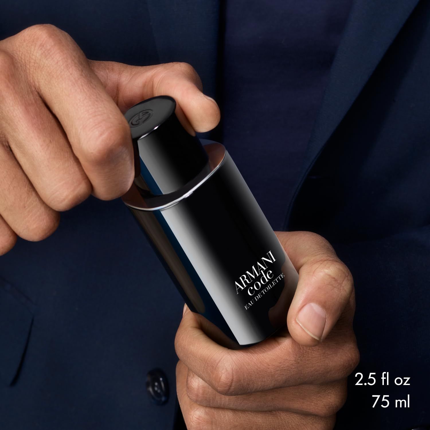 Uomo tiene un flacone Armani Code. Scritta: Armani Code Eau de Toilette. 2.5 fl oz.