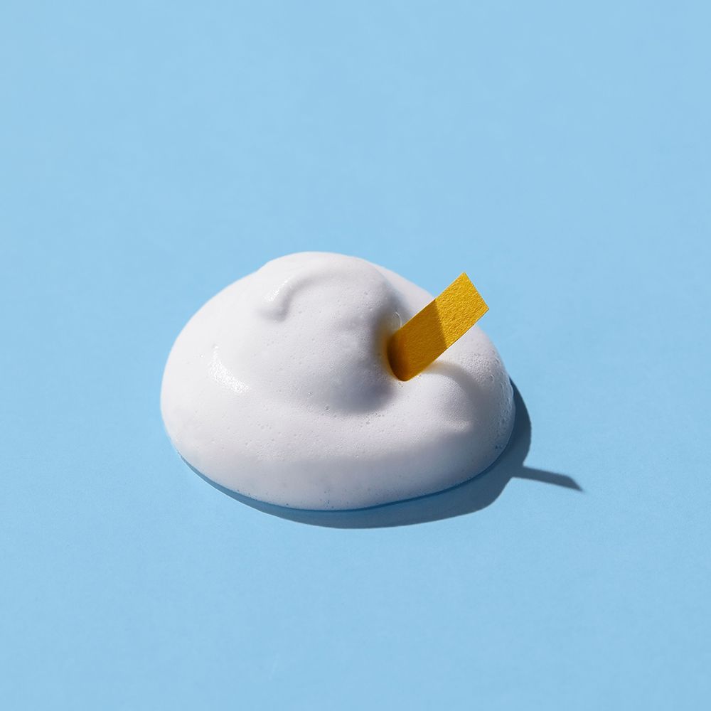 Schiuma bianca su sfondo blu. Striscia reattiva gialla inserita nella schiuma.