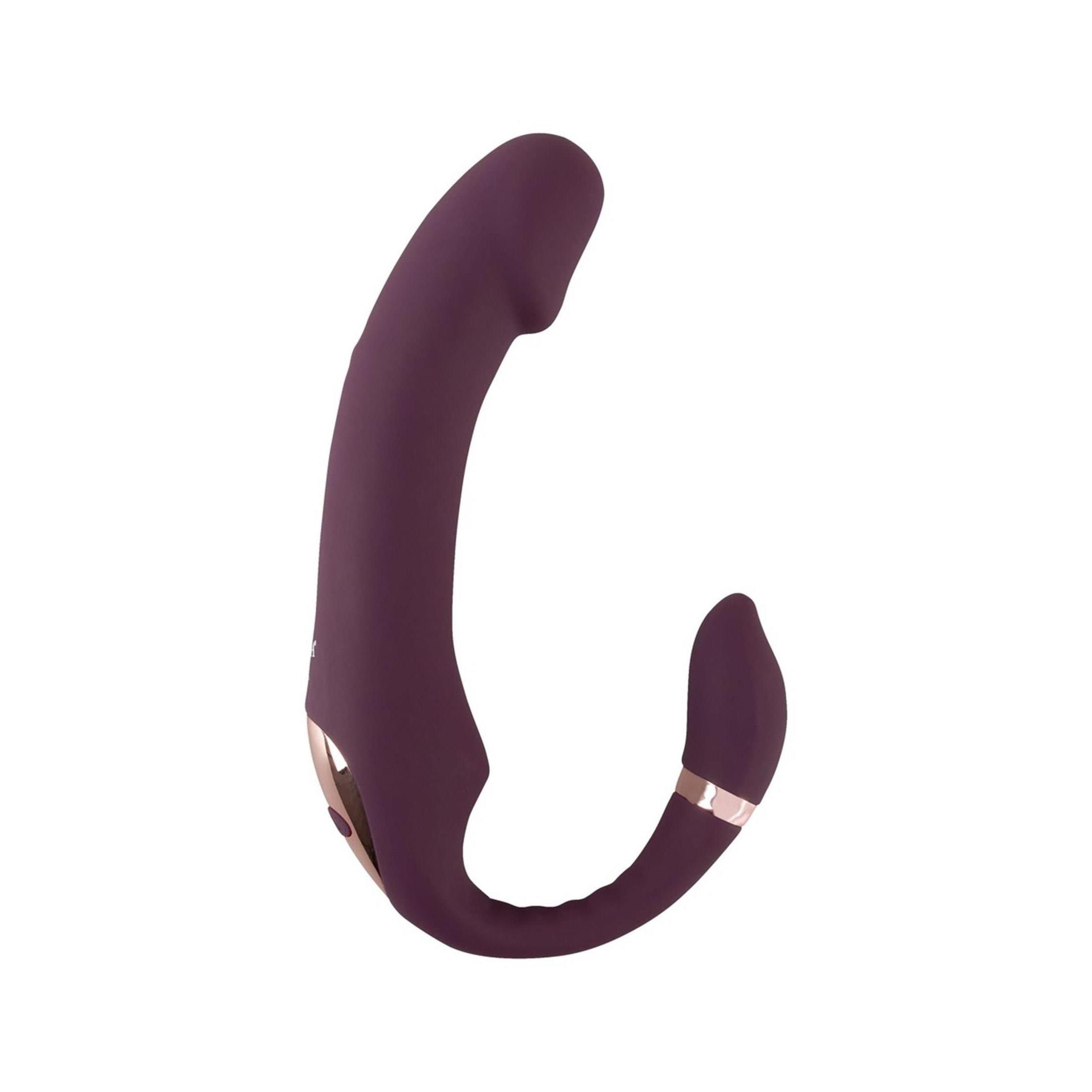 Vibratore viola a forma di U. Con un accessorio stimolatore e anelli dorati. Su sfondo bianco.