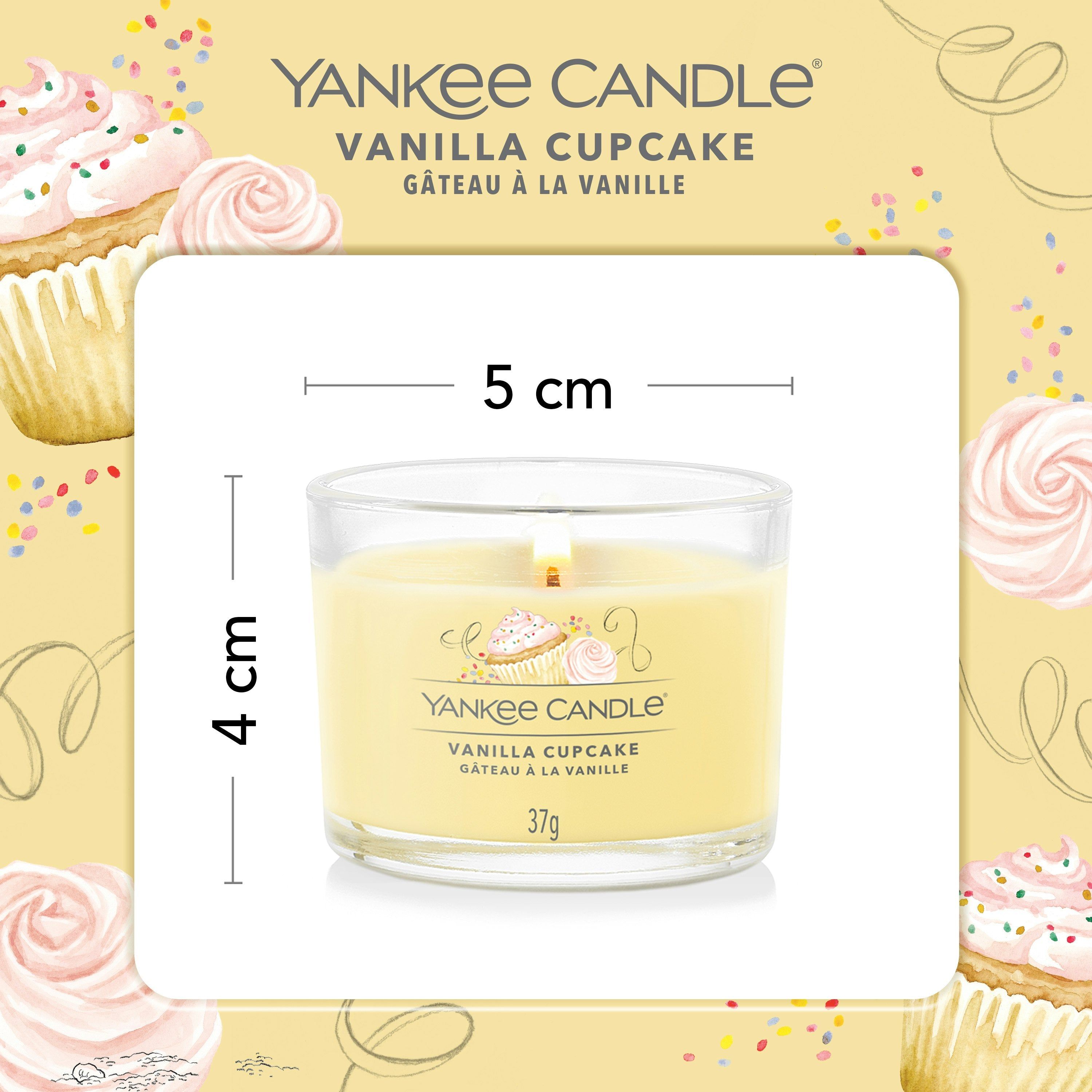 Candela in vetro, cera gialla. Scritta: Yankee Candle Vanilla Cupcake, 37g. Dimensioni: 4x5 cm.