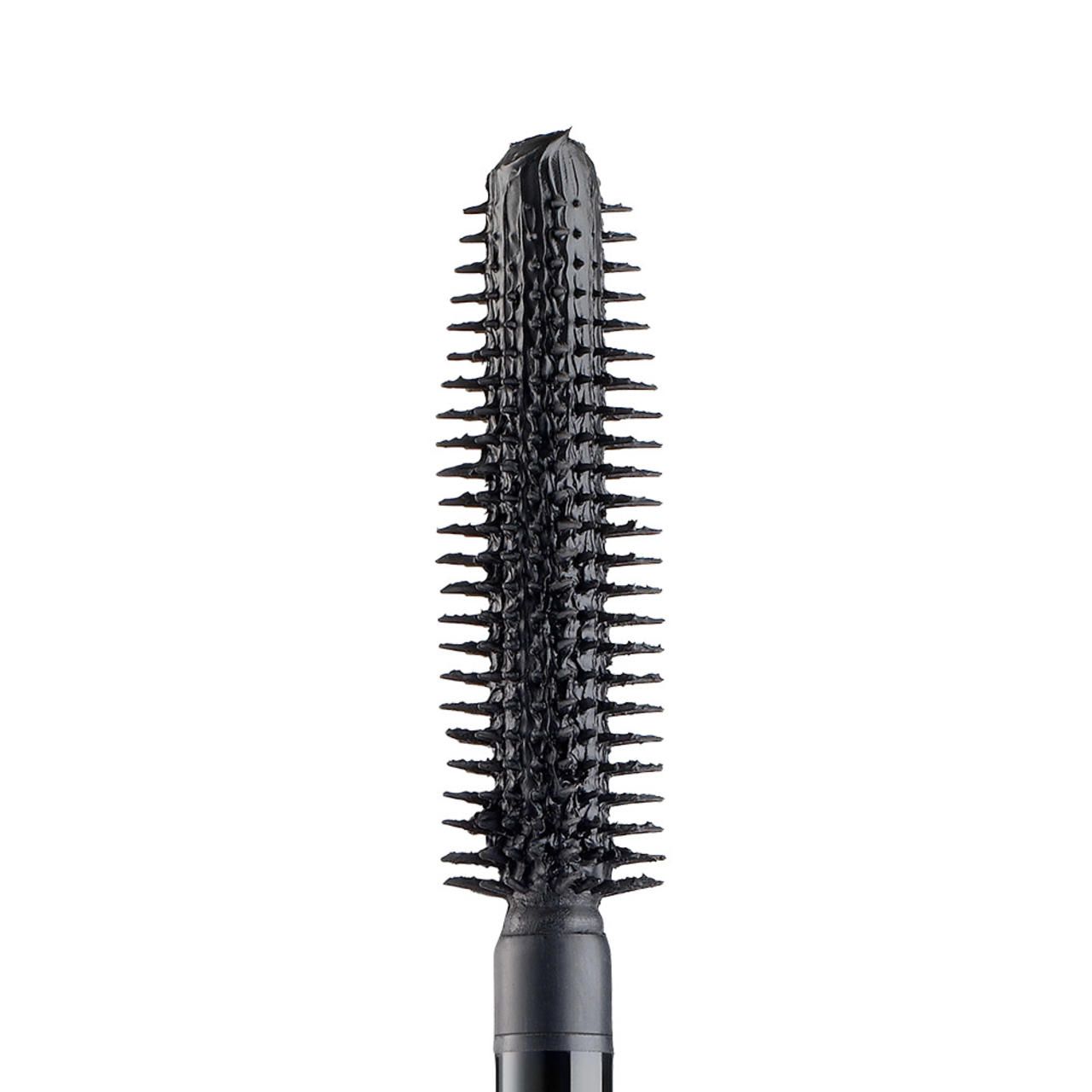 Primo piano di uno scovolino nero con setole. Lo scovolino è ricoperto di mascara.