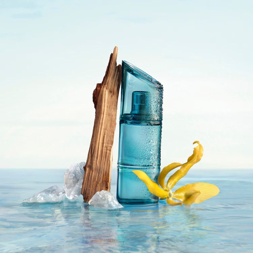 Flacone blu di KENZO HOMME Eau de Toilette Marine, legno, ghiaccio e fiore giallo sull'acqua.