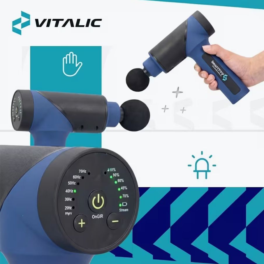 Pistola massaggiante, blu-nera. Pannello di controllo con pulsanti e LED. Logo VITALIC. Due testine massaggianti. Mano che tiene il dispositivo.