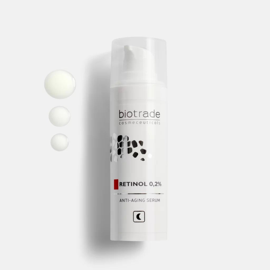 Siero bianco con dosatore a pompa. Scritta: Biotrade, Retinol 0,2%, Anti-Aging Serum. Accanto, tre gocce di siero.