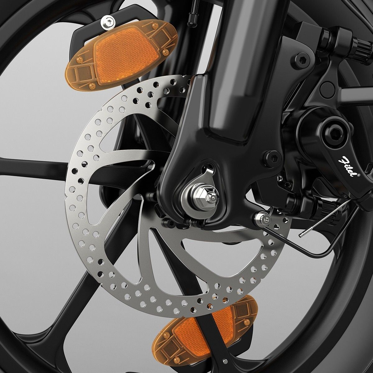 Primo piano del disco freno e dei catarifrangenti di una bici elettrica nera.