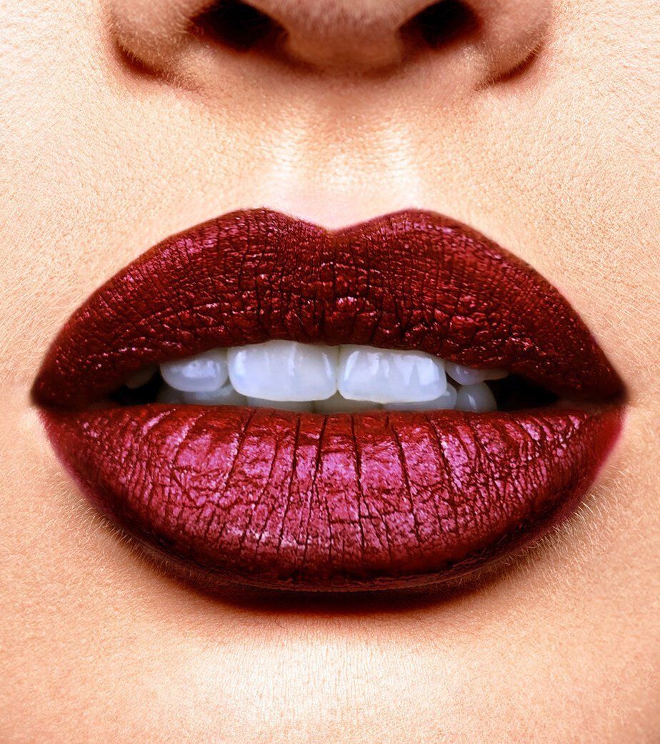 Labbra rosse con riflessi metallici e linee visibili.