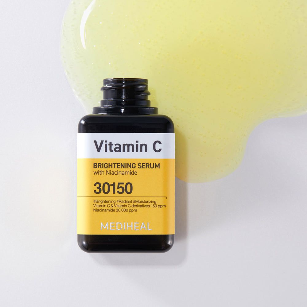 Flacone di siero con tappo nero. Etichetta gialla con testo: Vitamin C, 30150. Traccia di siero giallo.