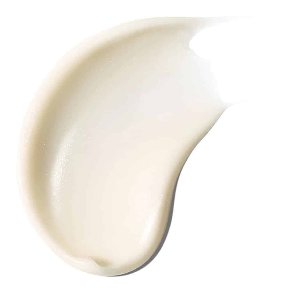 Primo piano di una sostanza color crema spalmata su una superficie bianca.