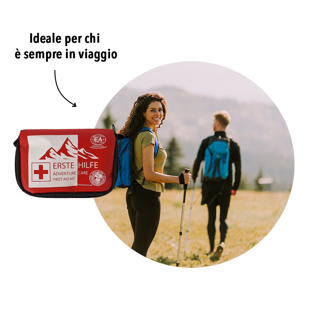 Persone che fanno escursioni con zaini. In primo piano, una borsa di pronto soccorso rossa.