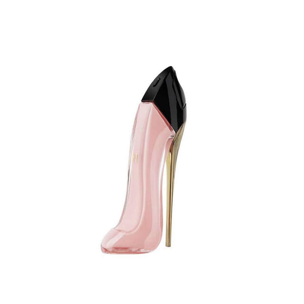 Flacone rosa a forma di scarpa con tacco dorato e tappo nero. In piedi.