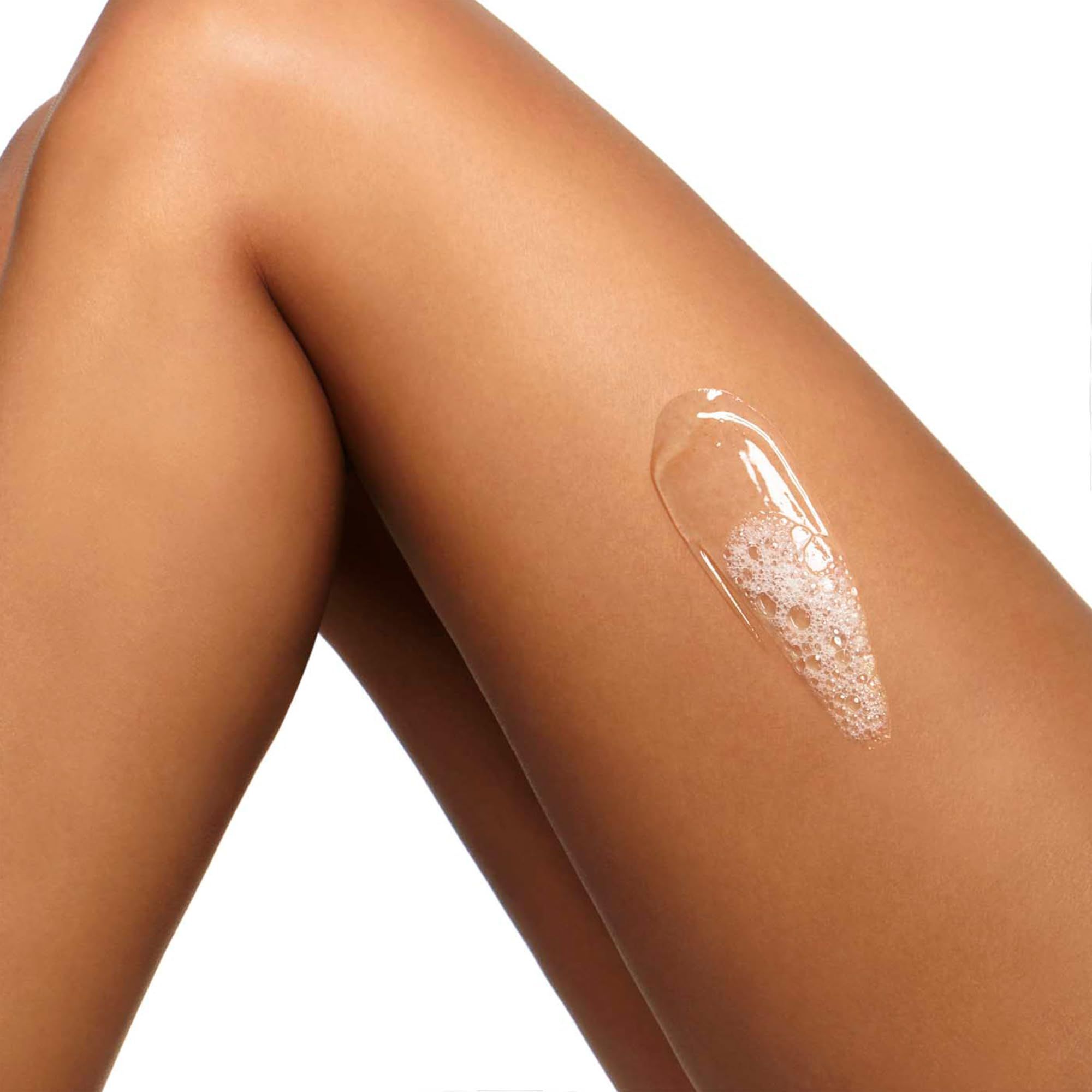 Applicazione di liquido trasparente su una gamba. Il liquido ha una consistenza schiumosa.