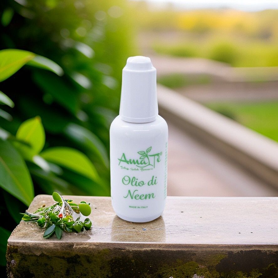Flacone bianco con etichetta verde. Amatè Olio di Neem. Su pietra, con piante sullo sfondo.