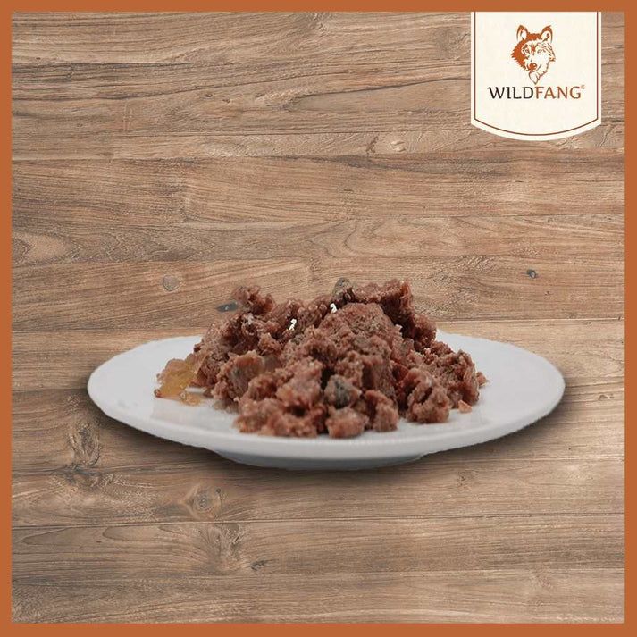 Piatto con cibo. Cibo marrone con pezzi di carne. Su sfondo di legno.