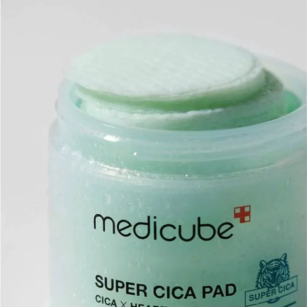 Primo piano di un contenitore aperto. Visibili i pad e la scritta MEDICUBE, SUPER CICA PAD. Coperchio e contenitore verdi.
