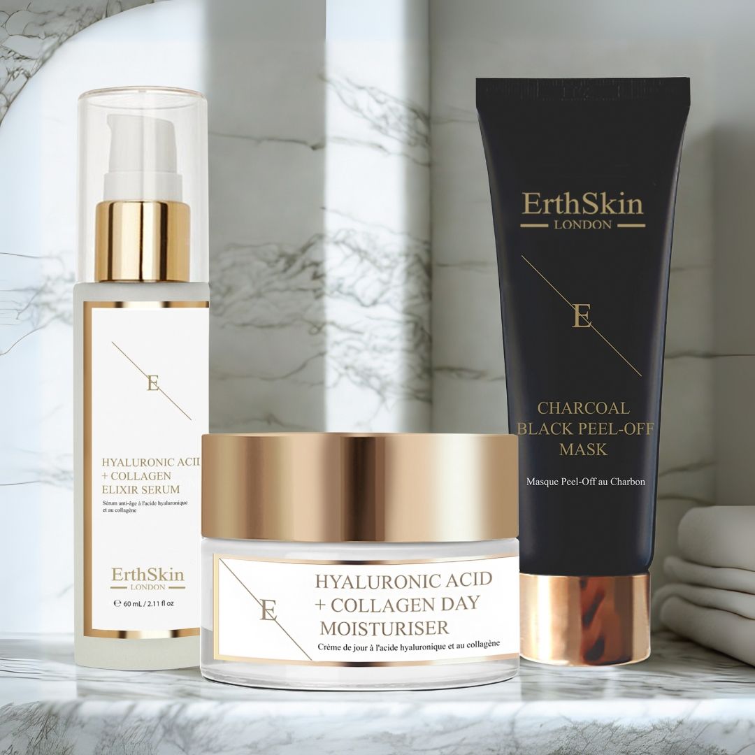 Set di siero, crema giorno e maschera. Prodotti con dettagli dorati ed etichette bianche. Su superficie marmorea.