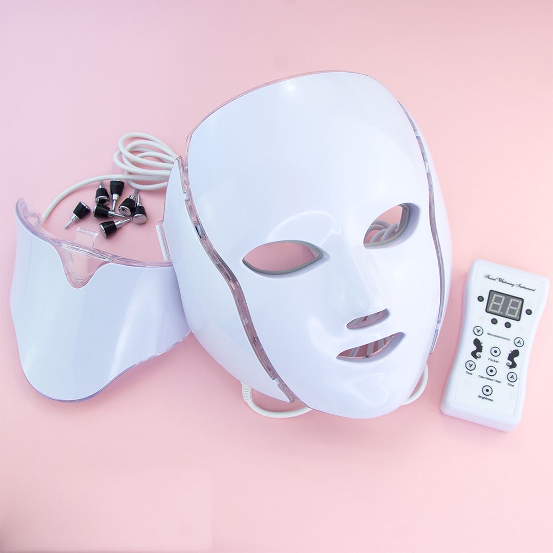 Maschera facciale a LED bianca con collo, telecomando e accessori. La maschera ha aperture per occhi, naso e bocca.