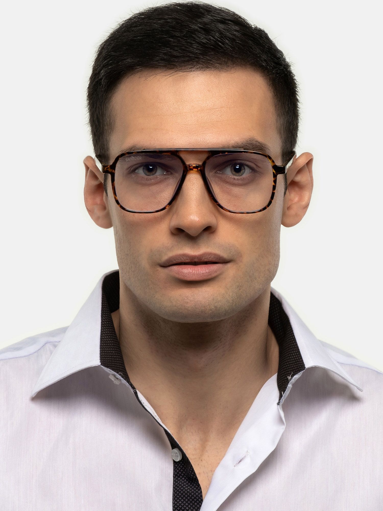 Uomo con occhiali marroni a fantasia tartarugata. Lenti rettangolari, doppio ponte. Primo piano.