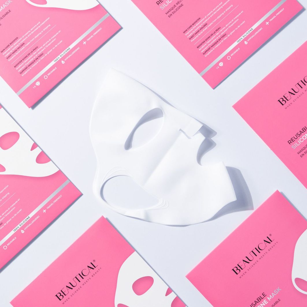 Maschera in silicone bianca e confezioni rosa. Testo: BEAUTICAL, REUSABLE SILICONE MASK. Maschera appoggiata sulle confezioni.