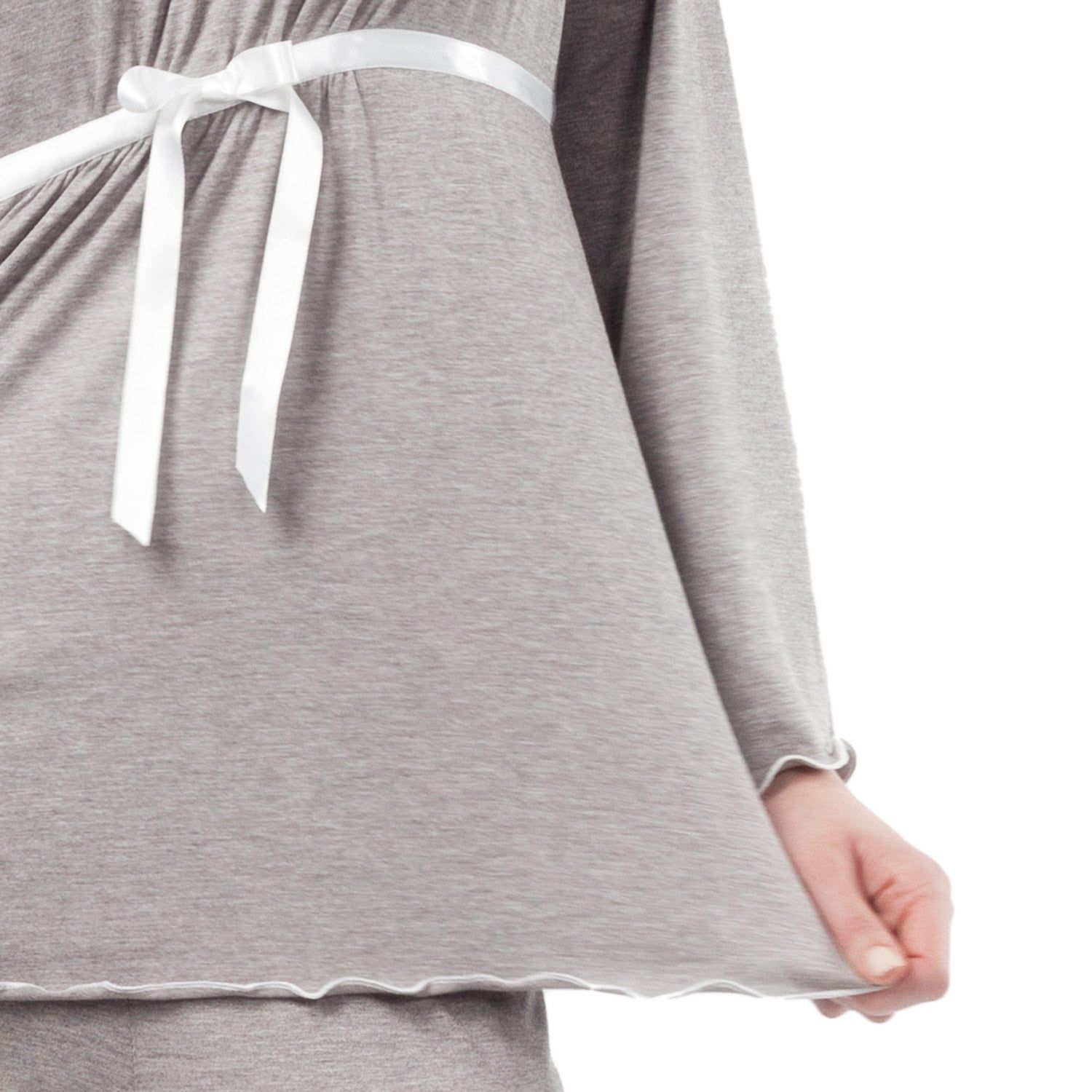 Primo piano del top del pigiama premaman grigio. Nastro bianco, maniche lunghe. Orlo smerlato.