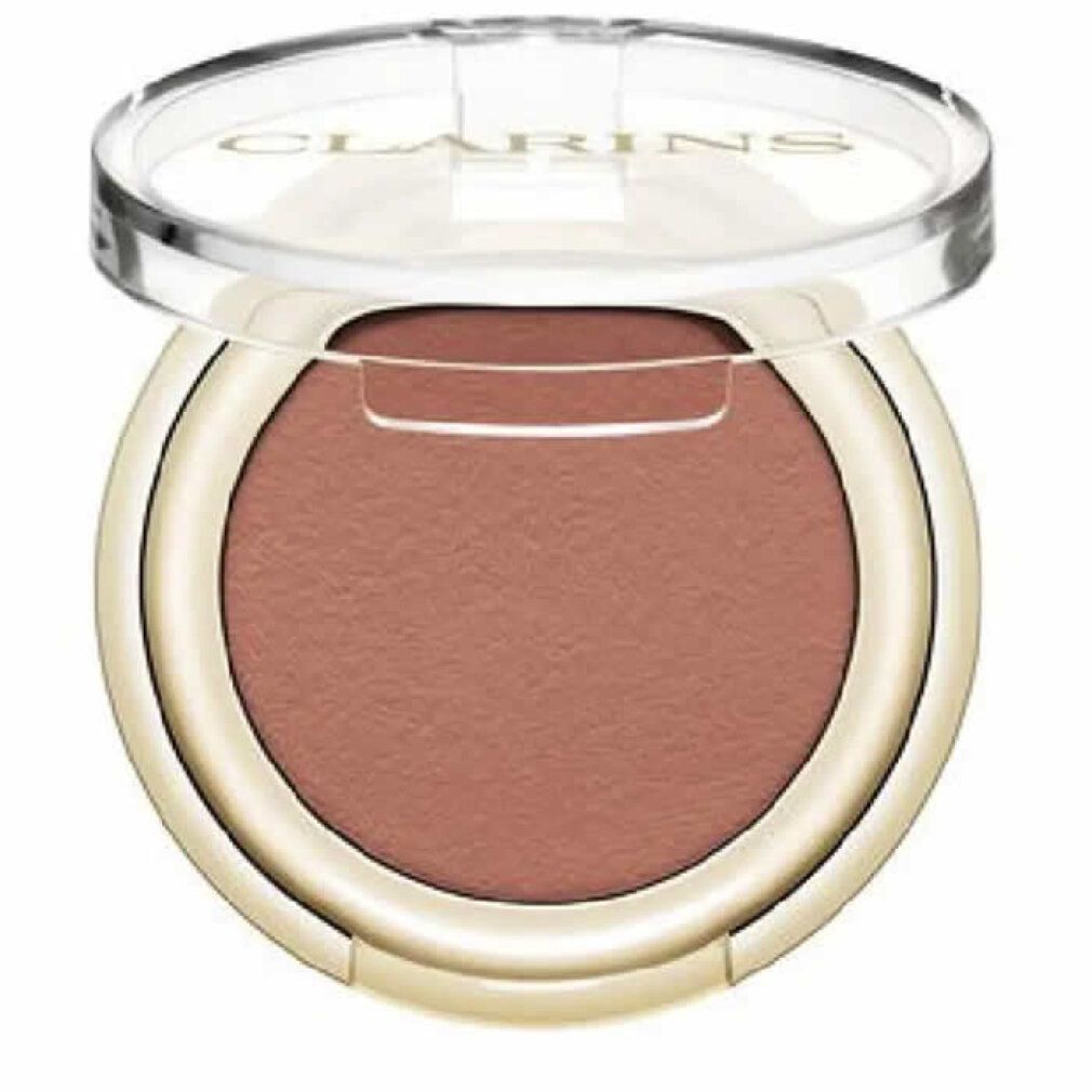 Contenitore rotondo di ombretto con ombretto rosa-marrone. Coperchio aperto. Bordo dorato. Coperchio trasparente con logo.