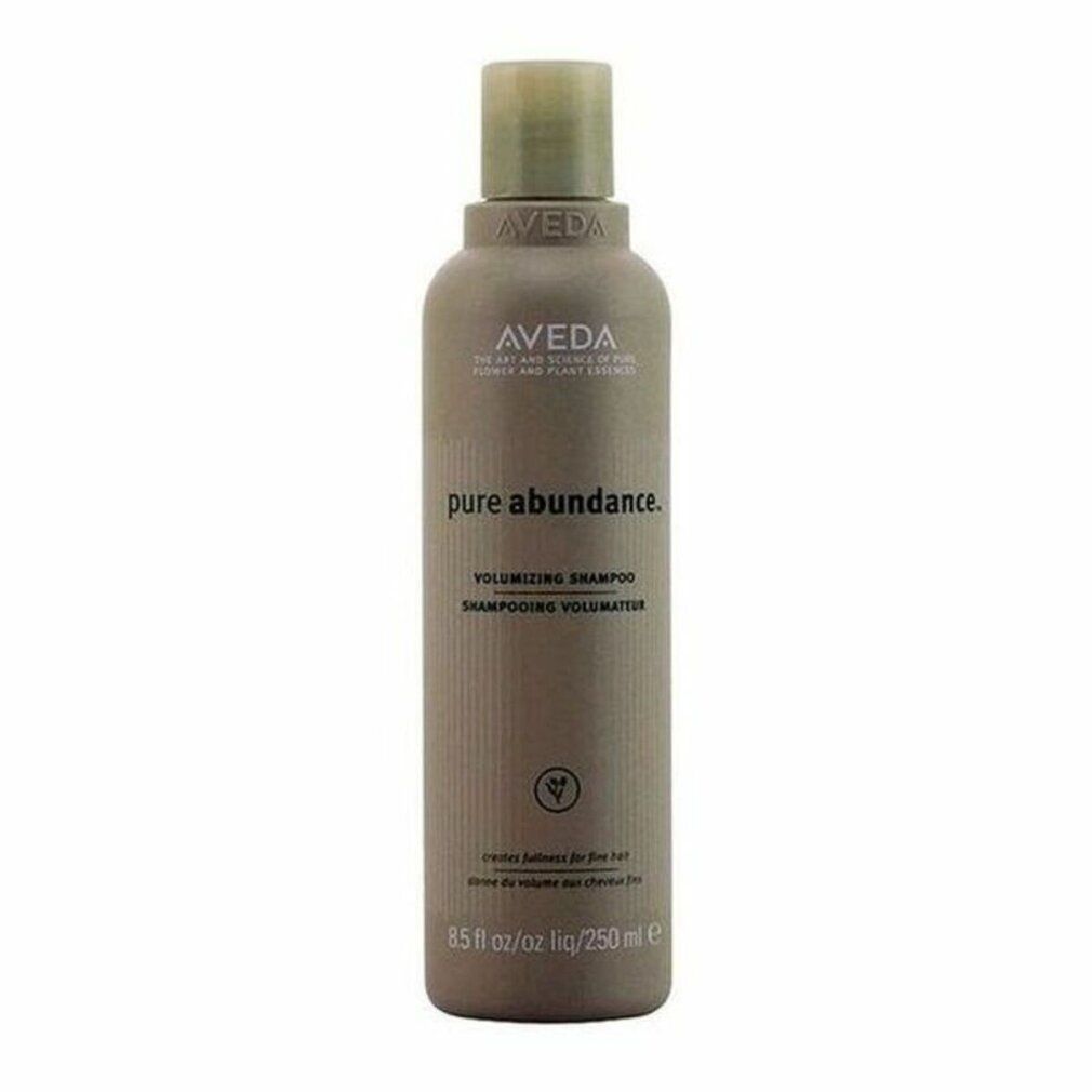 Piccolo flacone marrone con logo Aveda e nome del prodotto. Testo: Pure Abundance Volumizing Shampoo. Illustrazione vegetale verde.
