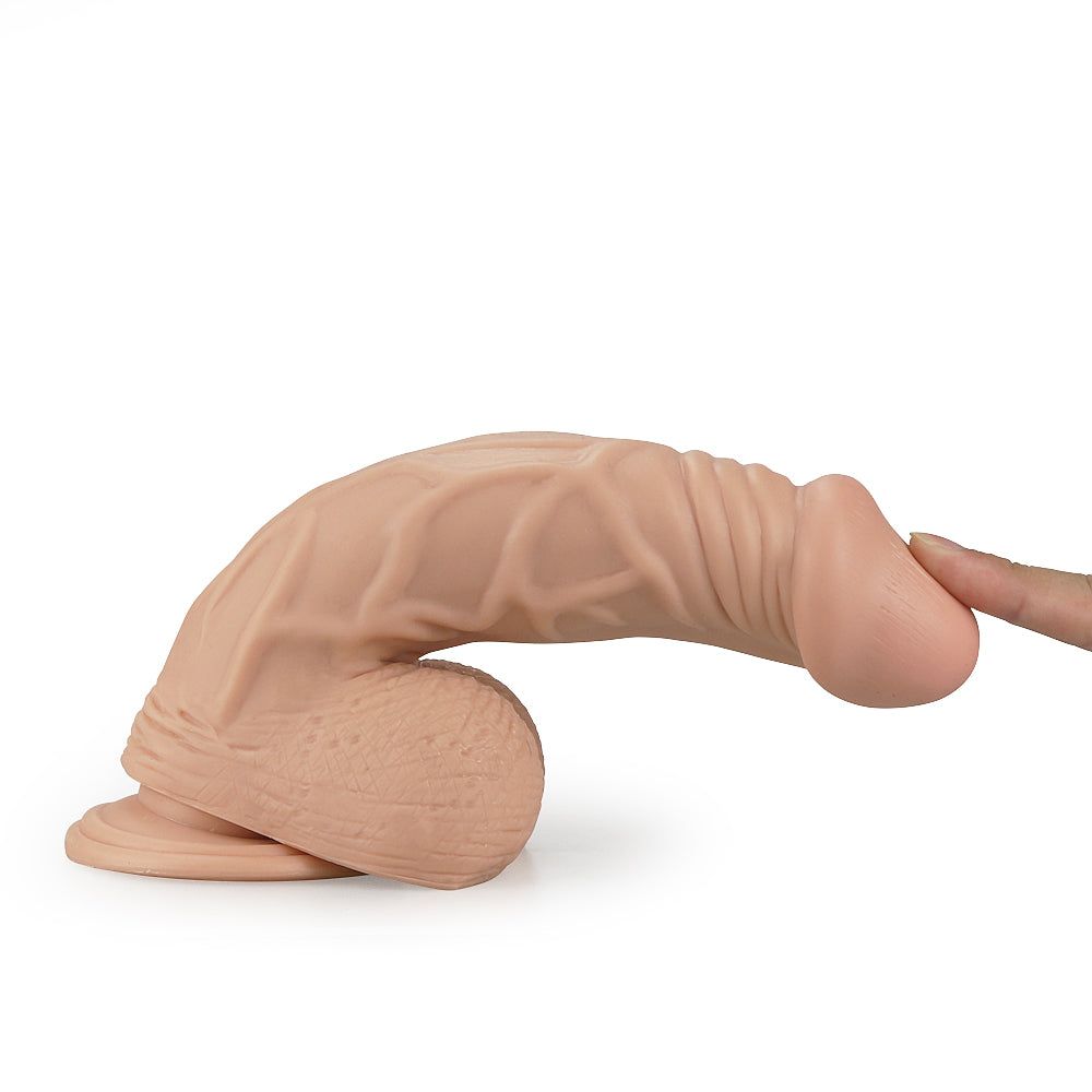 Dildo beige con texture realistica. Un dito tocca la punta.