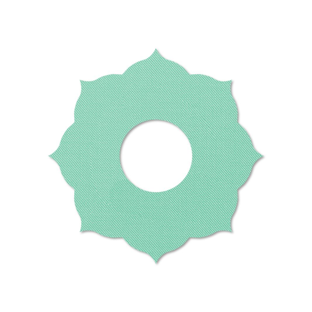 Anello di fissaggio turchese con design floreale e foro centrale. Superficie strutturata. Sfondo bianco.